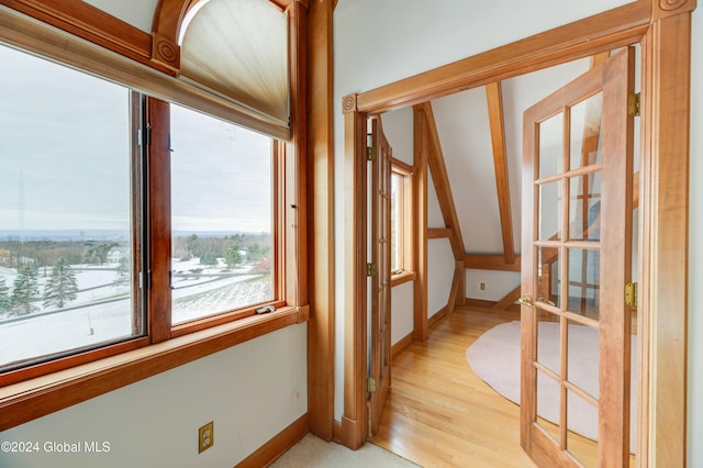 corridor with french doors and light hardwood / wood-style flooring