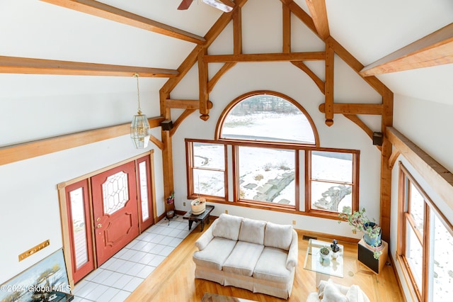 tiled living room featuring beam ceiling and high vaulted ceiling