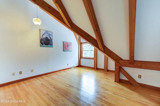 additional living space with beam ceiling and light wood-type flooring