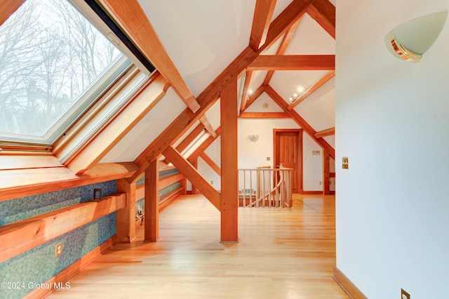 additional living space featuring beamed ceiling, high vaulted ceiling, and light hardwood / wood-style floors