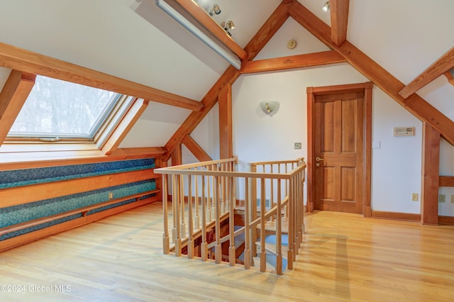 additional living space featuring wood-type flooring, high vaulted ceiling, and a skylight