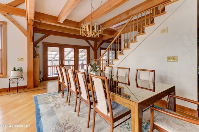 dining area featuring hardwood / wood-style floors, beam ceiling, french doors, and an inviting chandelier