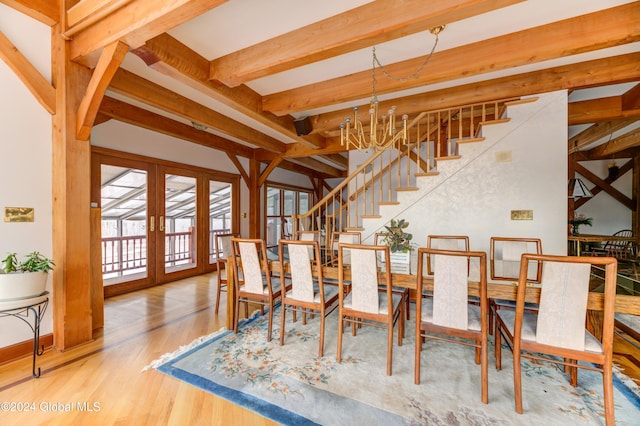 dining space with beamed ceiling, an inviting chandelier, wood-type flooring, and french doors