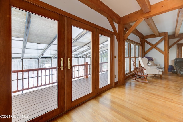 doorway with beam ceiling, light hardwood / wood-style flooring, and french doors