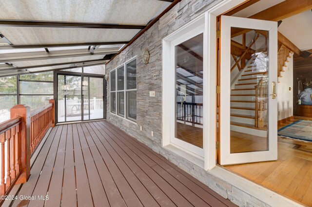 unfurnished sunroom featuring lofted ceiling with beams