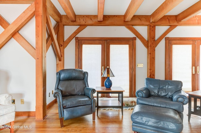 sitting room featuring beam ceiling, light hardwood / wood-style flooring, and french doors