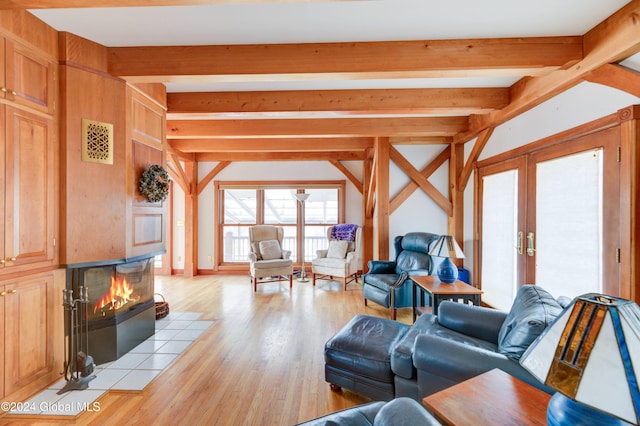 living room featuring beamed ceiling, french doors, and light hardwood / wood-style flooring