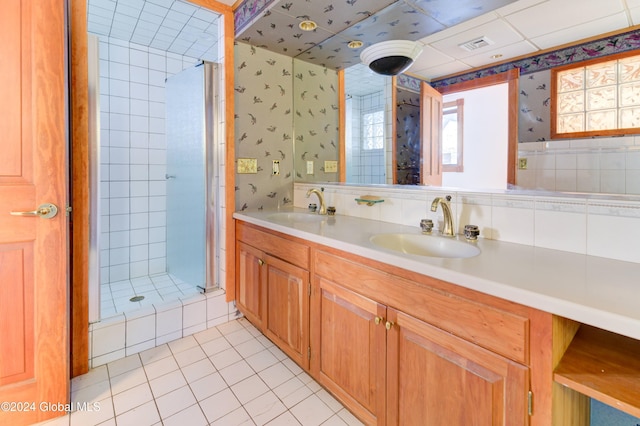 bathroom featuring a tile shower, vanity, and tile patterned floors