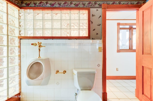 bathroom with tile patterned floors, tile walls, and toilet