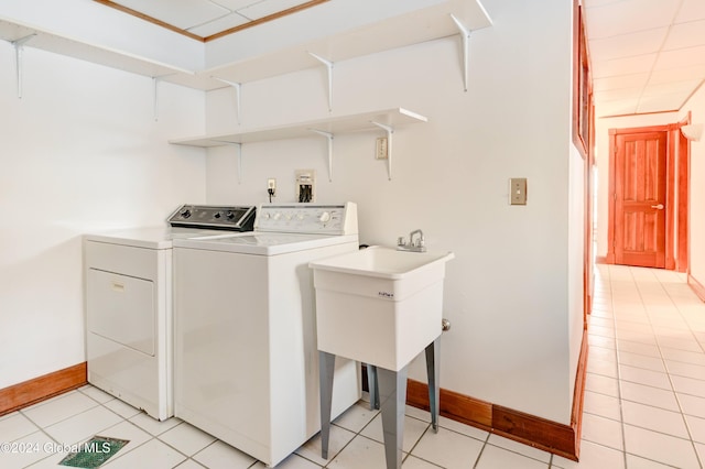 clothes washing area featuring light tile patterned flooring and washing machine and dryer