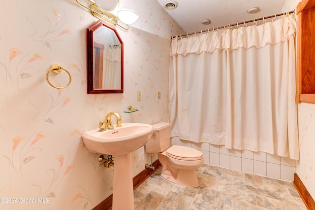 bathroom with a shower with curtain, toilet, and sink