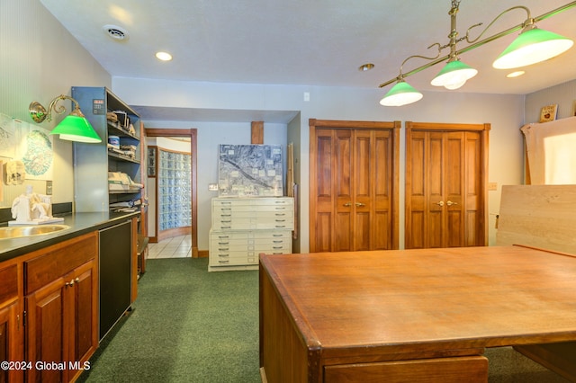 kitchen featuring dishwasher, hanging light fixtures, dark carpet, and sink