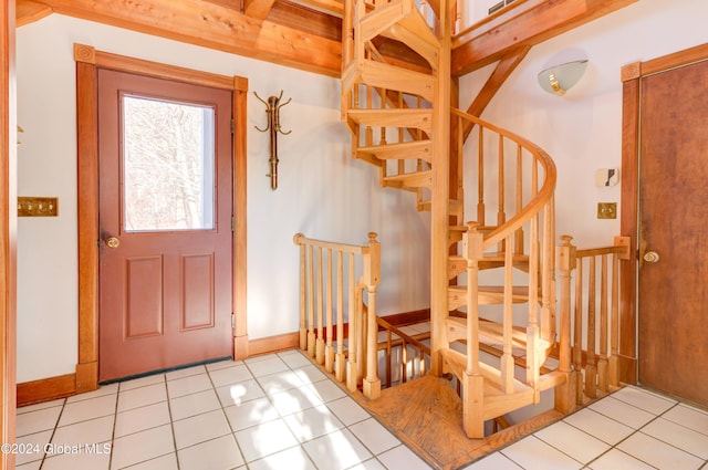 tiled foyer featuring beamed ceiling