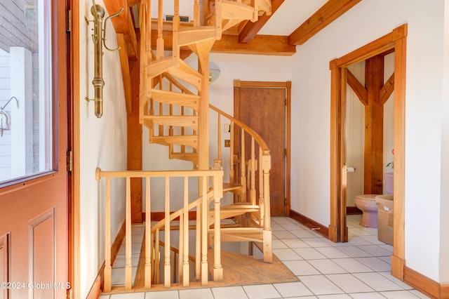 stairway with beamed ceiling and tile patterned floors