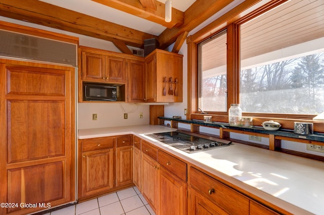 kitchen with paneled built in refrigerator, light tile patterned floors, and stainless steel gas stovetop