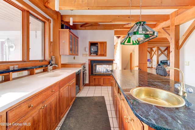 kitchen featuring beam ceiling, light tile patterned floors, hanging light fixtures, and sink