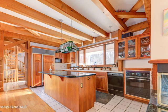 kitchen with black appliances, decorative light fixtures, beamed ceiling, a center island, and light tile patterned flooring