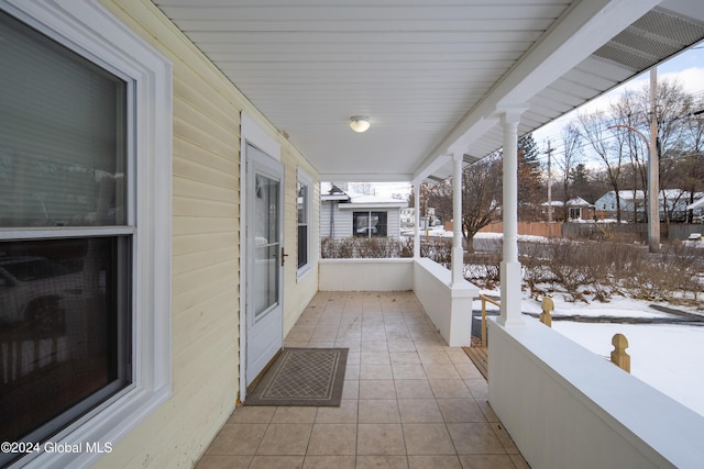 snow covered patio featuring covered porch