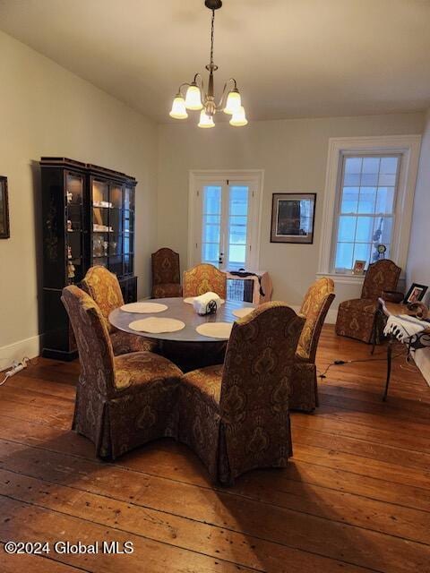 dining room with dark wood-type flooring and a notable chandelier