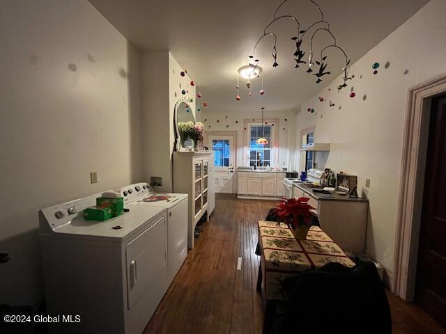 kitchen with independent washer and dryer, dark hardwood / wood-style flooring, and white cabinetry