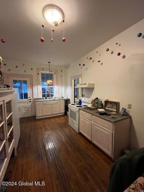 kitchen with dark wood-type flooring, sink, electric stove, pendant lighting, and range hood