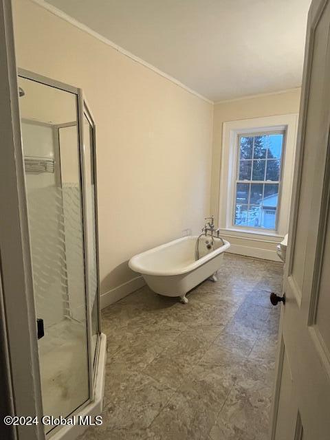 bathroom featuring ornamental molding and independent shower and bath