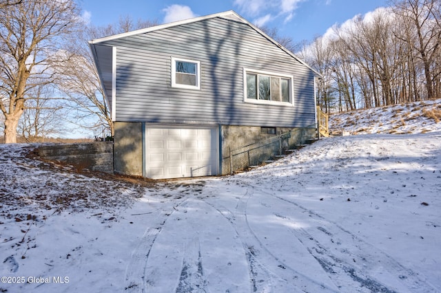 view of snowy exterior featuring a garage