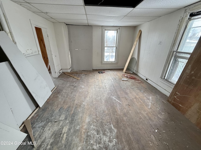 interior space with a paneled ceiling, dark wood-type flooring, and multiple windows