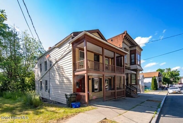 exterior space with covered porch and a balcony