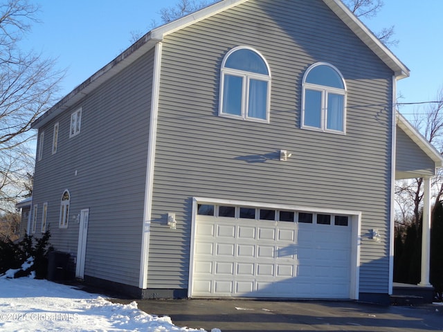 view of snowy exterior with a garage