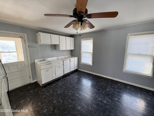 kitchen featuring a wealth of natural light, white cabinetry, and crown molding