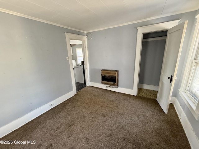 unfurnished living room with heating unit, crown molding, a healthy amount of sunlight, and dark colored carpet