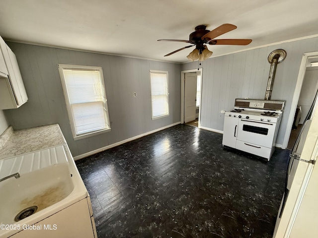 kitchen featuring white gas range oven, hanging light fixtures, ceiling fan, ornamental molding, and fridge