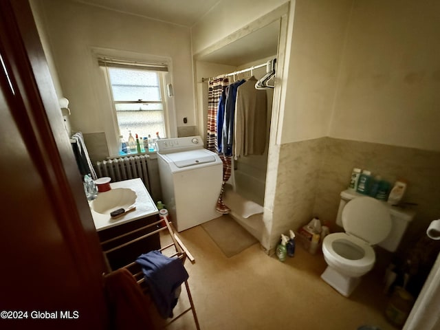 bathroom featuring vanity, toilet, walk in shower, radiator heating unit, and washer / clothes dryer