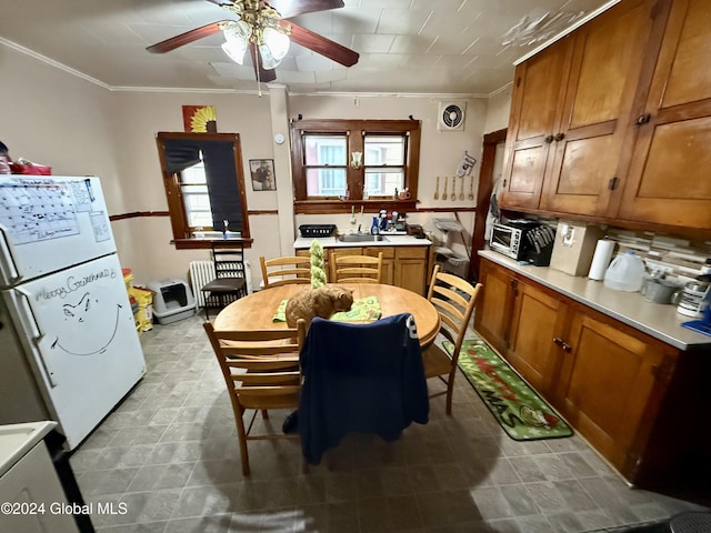 kitchen with decorative backsplash, crown molding, white fridge, and ceiling fan