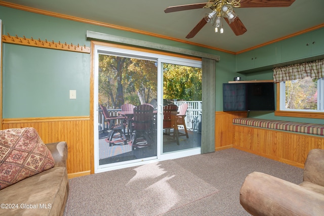 living room featuring carpet flooring, crown molding, and ceiling fan