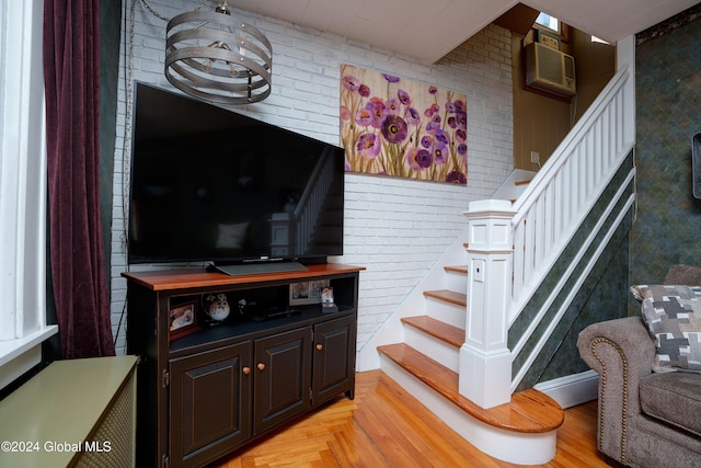 staircase featuring a wall mounted AC, parquet floors, and brick wall