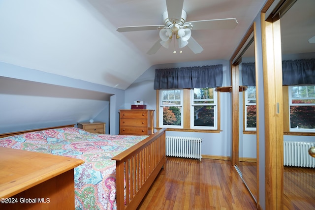 bedroom featuring ceiling fan, radiator heating unit, lofted ceiling, and light hardwood / wood-style flooring