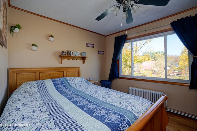 bedroom with radiator, ceiling fan, a textured ceiling, hardwood / wood-style flooring, and ornamental molding