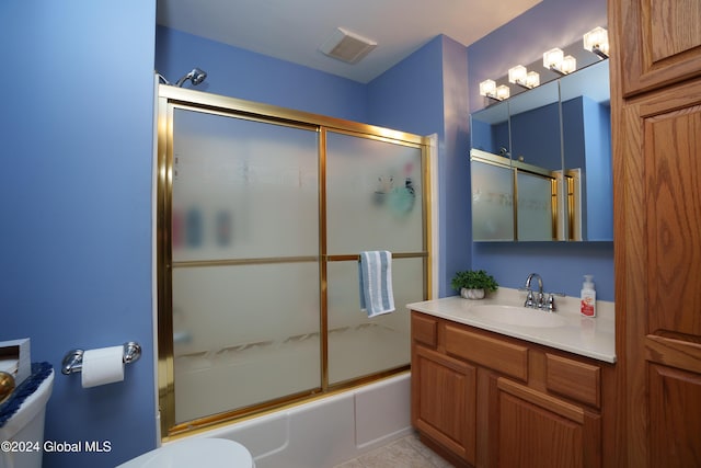 full bathroom featuring tile patterned flooring, combined bath / shower with glass door, toilet, and vanity