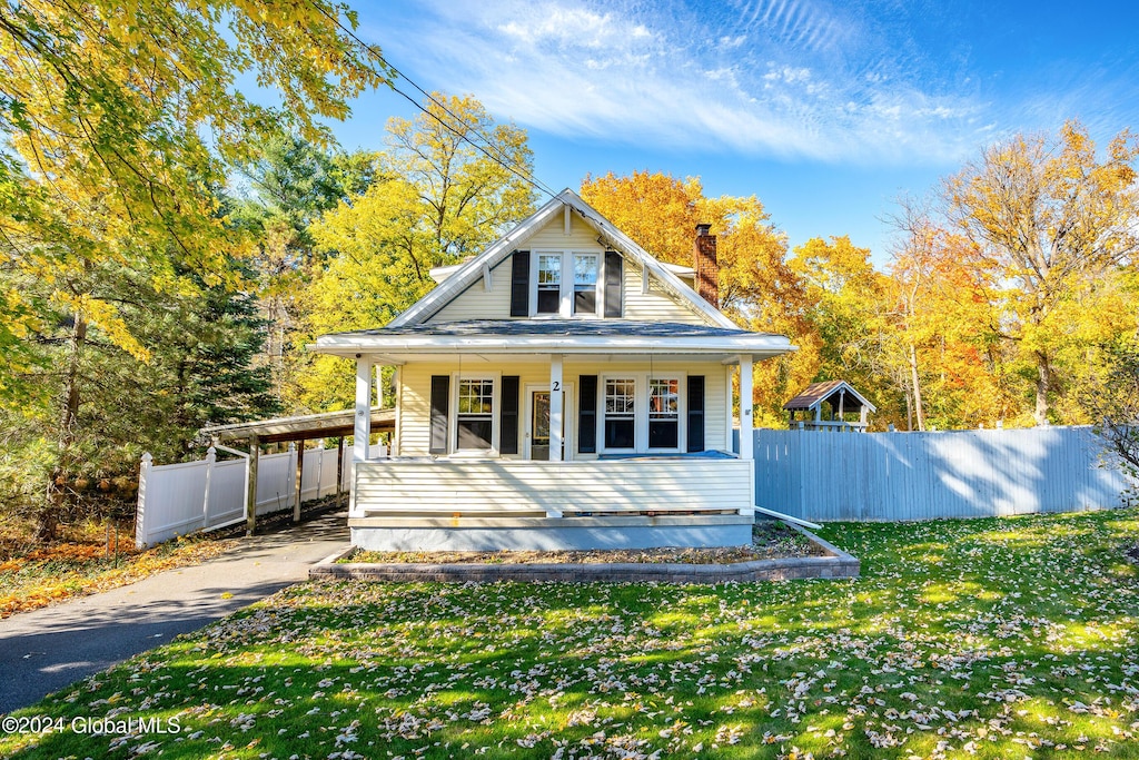 exterior space featuring a lawn, a porch, and a carport