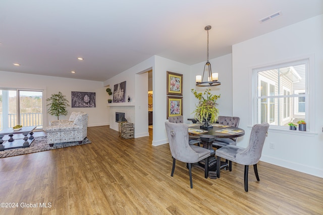dining space with an inviting chandelier and light hardwood / wood-style flooring