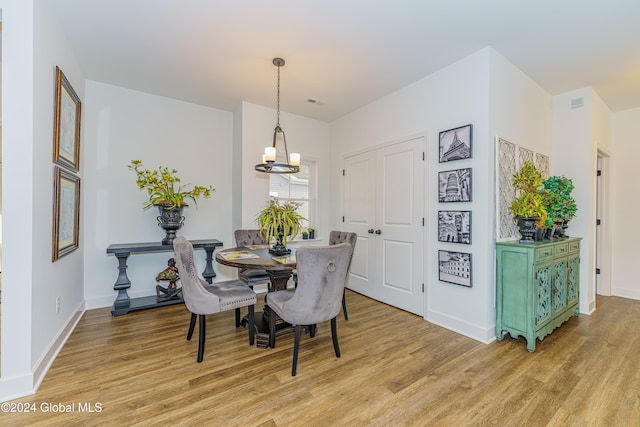 dining space with a notable chandelier and light wood-type flooring