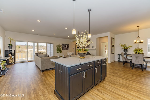 kitchen featuring a center island, light wood-type flooring, hanging light fixtures, and an inviting chandelier