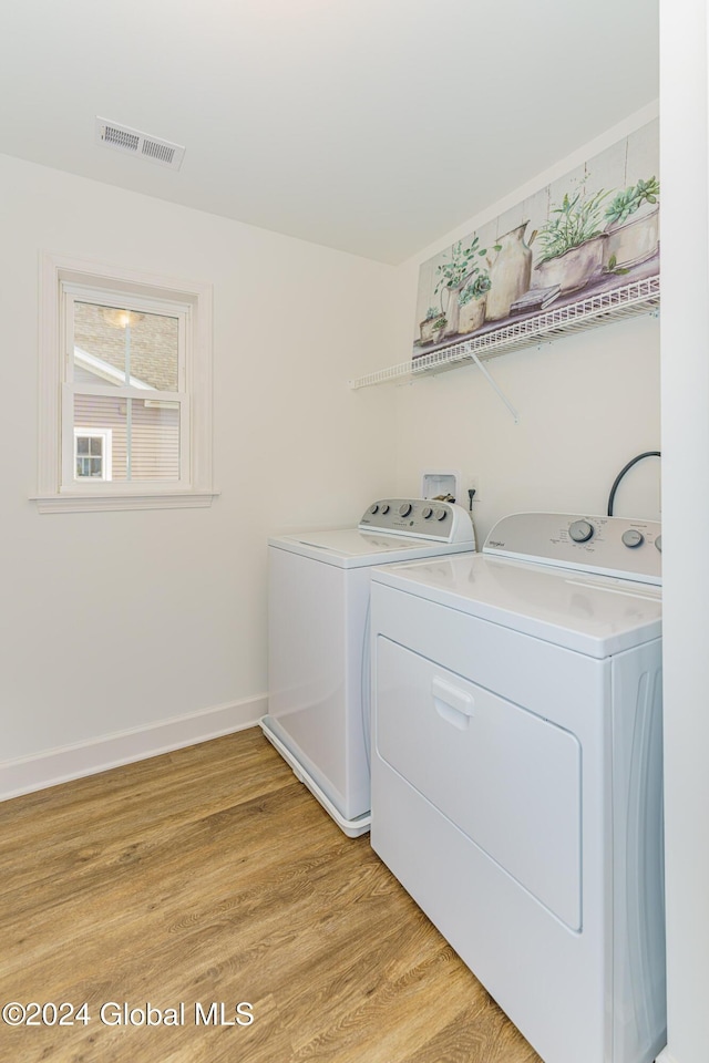 washroom featuring washer and dryer and light hardwood / wood-style flooring