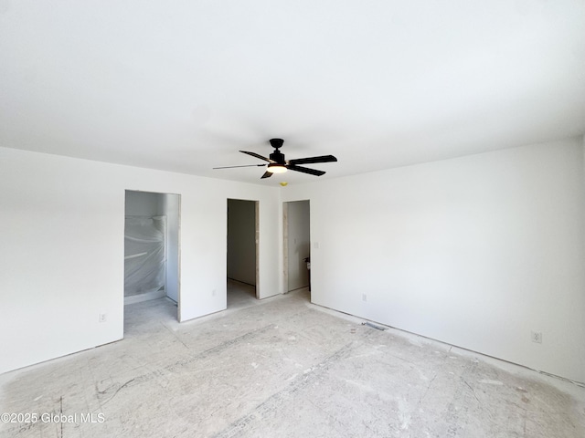 unfurnished bedroom featuring ceiling fan and a walk in closet