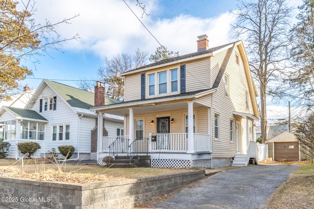 view of front of house with a porch, a garage, and an outdoor structure