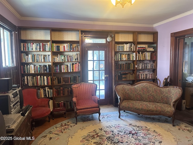 living area with wood finished floors and ornamental molding