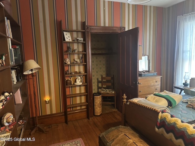 bedroom featuring wallpapered walls, multiple windows, and hardwood / wood-style floors