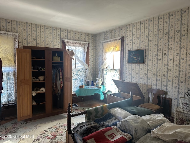 bedroom with a closet and wallpapered walls